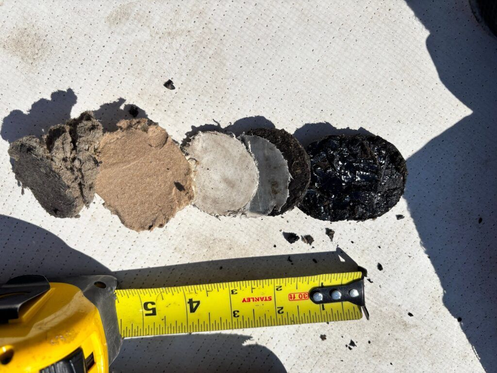 A core sample on a low slope commercial roof that illustrates the existing layers of roofing material.