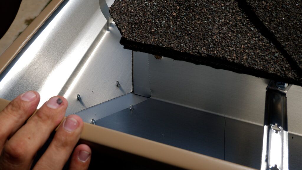 Inside of new seamless gutters with hidden hangar mounting system visible and the joint seam visible before sealant is applied.