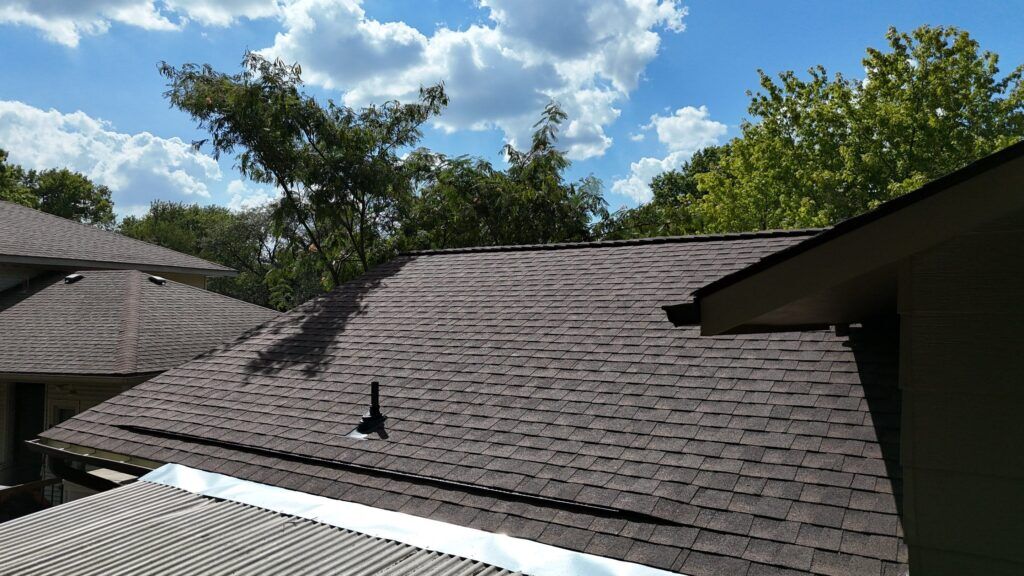 Lomanco's Deck-Air intake vent installed off-edge on a rafter-tailed house by a covered porch.