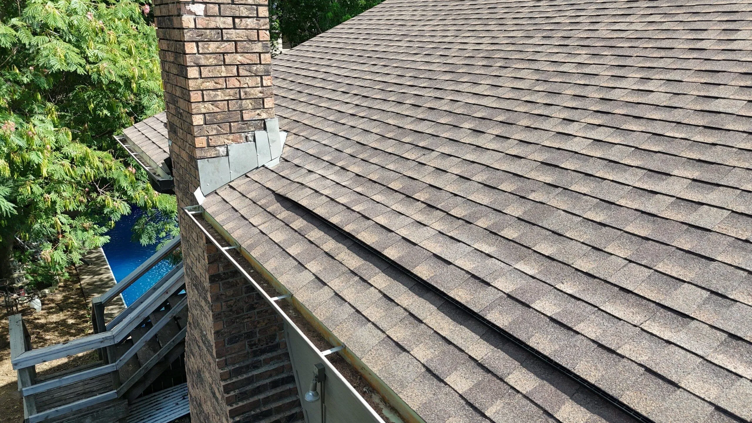 Lomanco Deck-Air intake vent installed off-edge on a rafter-tailed house.