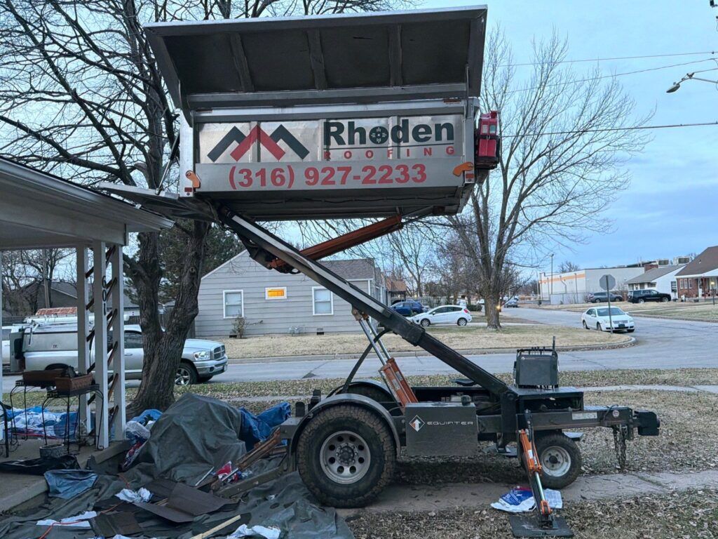 Rhoden Roofing Equipter raised to the roofline to catch debris during a roof replacement