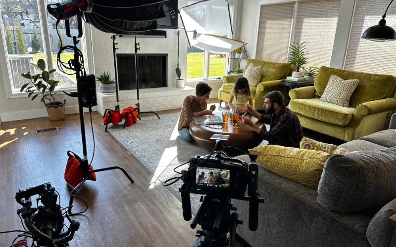 Homeowners spend time with their daughter behind the scenes of a commercial for Rhoden Roofing.