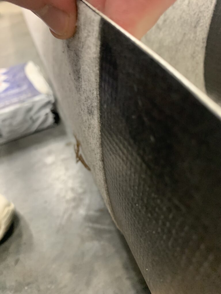 The fleece lining and the bottom ply of a roll of TPO are both visible, illustrating the added density that fleece lining can offer.