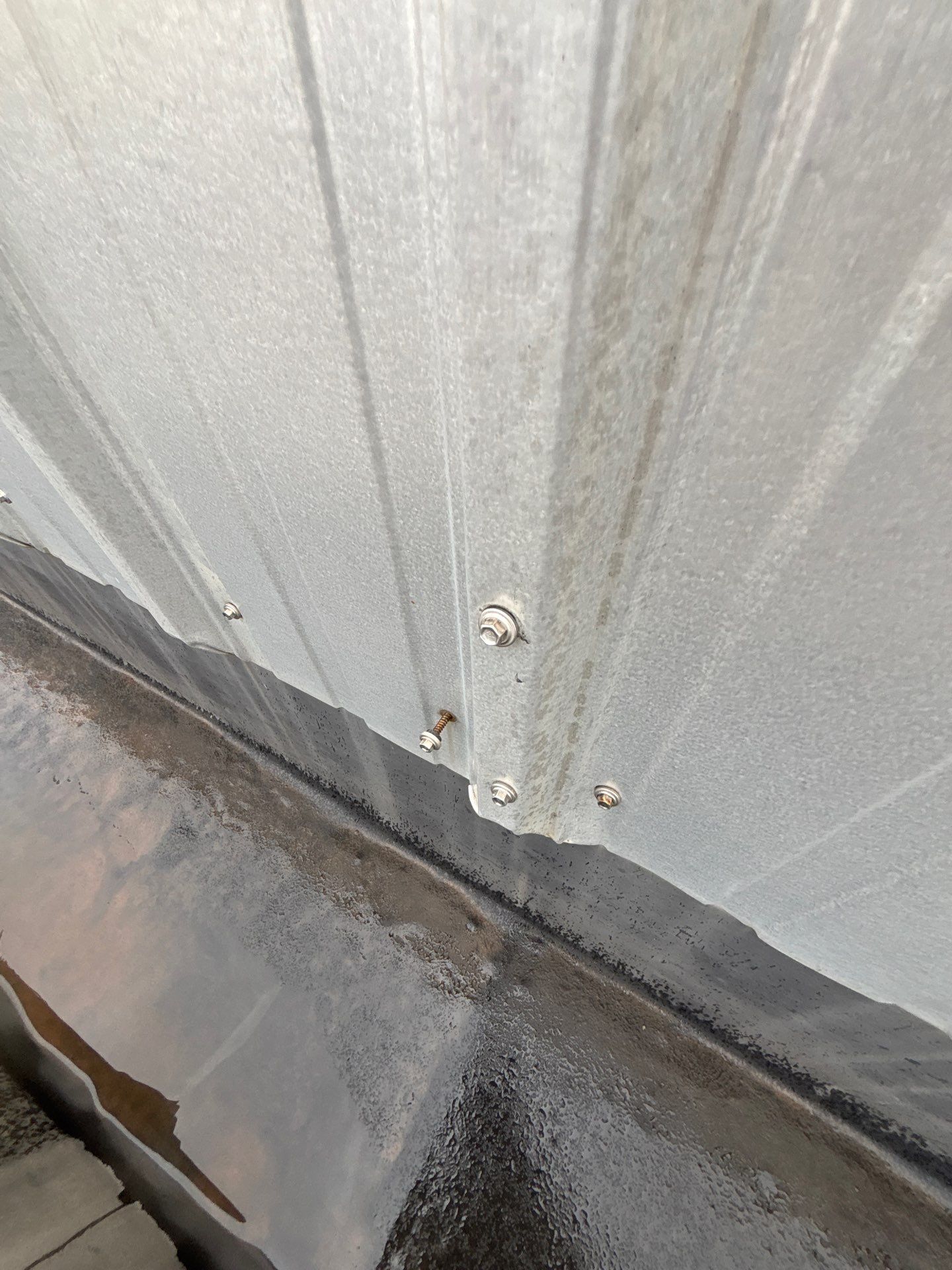 A fastener on a commercial low slope standing seam metal roof pulling out due to thermal expansion.