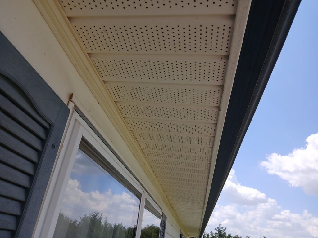 Continuously vented vinyl soffits under a house's eaves. Repairs to vinyl soffits often necessitate replacement of the entire panel.