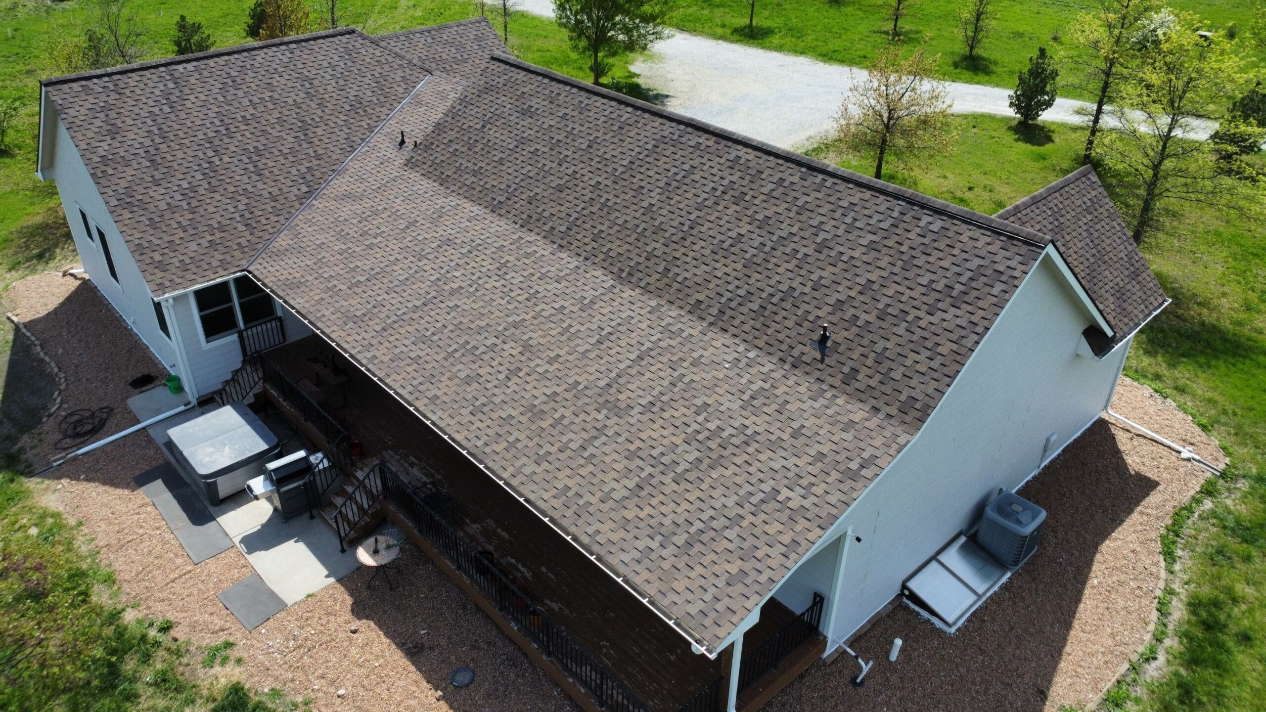Roof with Long Drive and Septic Lines An asphalt shingle Grand Sequoia roof completed by Rhoden Roofing that required access through a long driveway and navigation around sensitive septic tank lines.