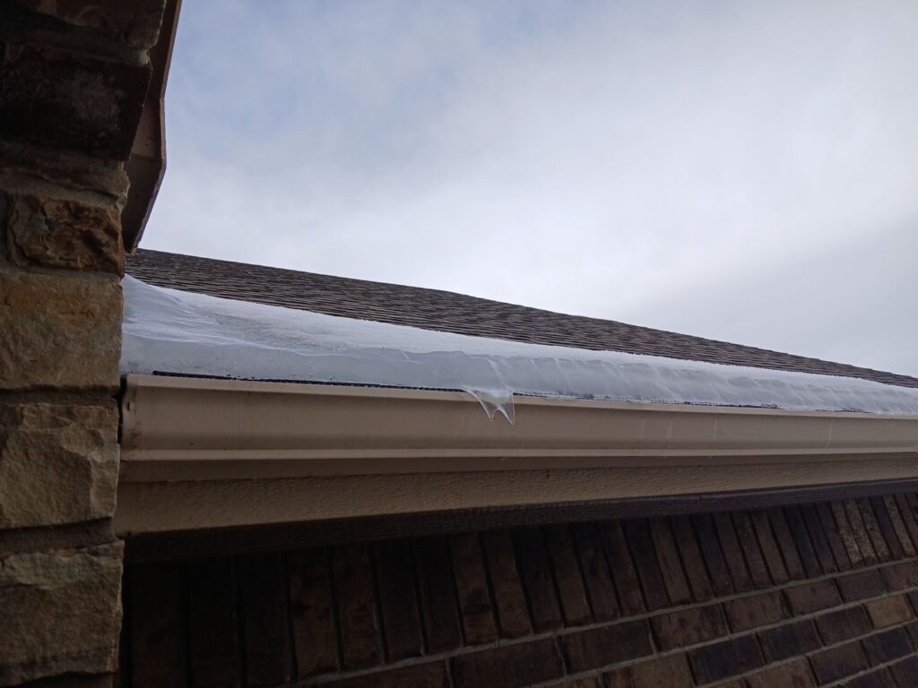 Snow melted on the field of a roof while it remains frozen at the eaves -- a textbook ice dam.