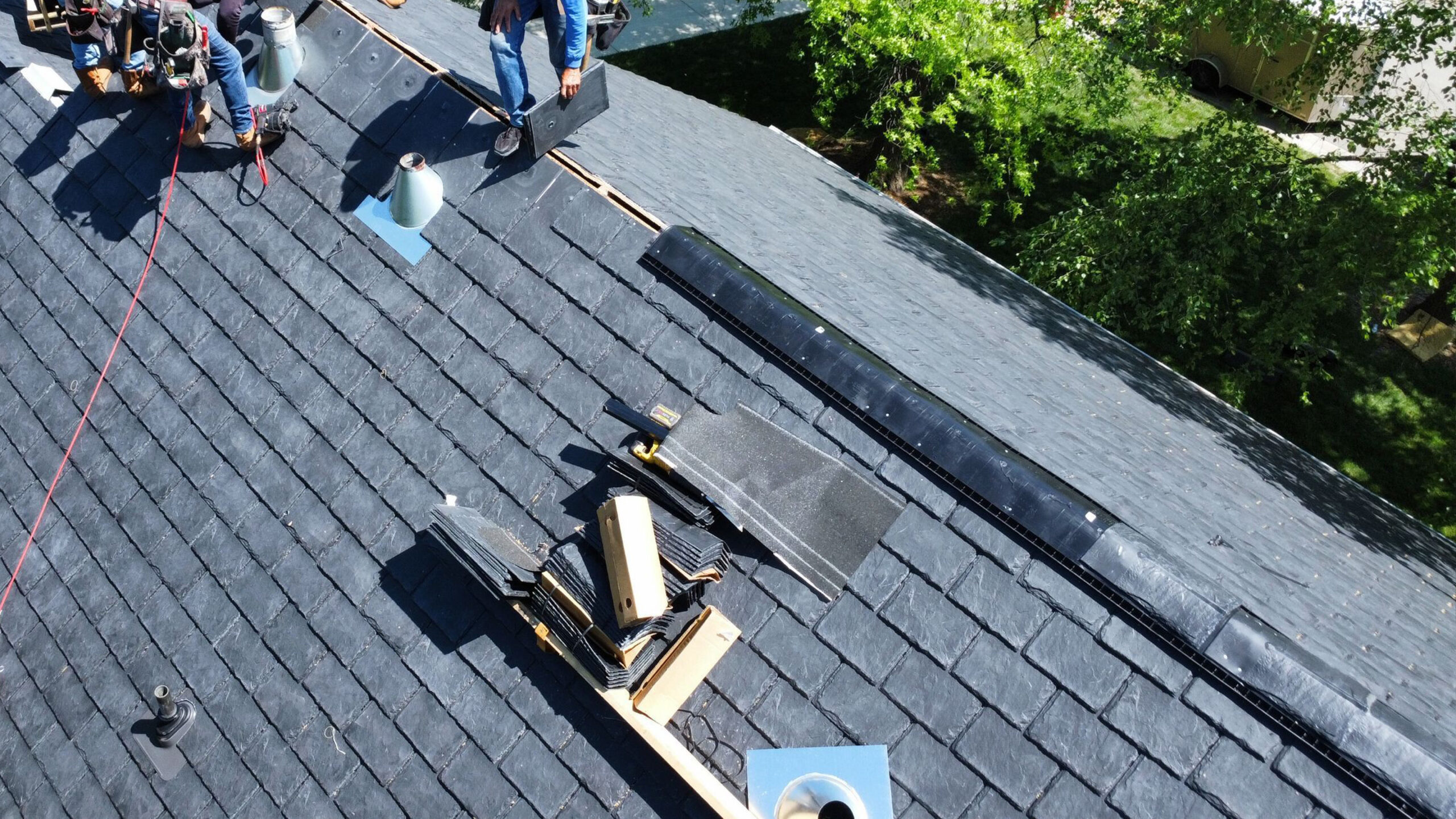 Synthetic slate ridge showing open vent, vent cover, and ridge cap installation in progress Synthetic slate ridge showing open vent, vent cover, and ridge cap installation in progress