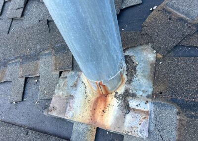 Heater flue base flashing with rust during a roof replacement.