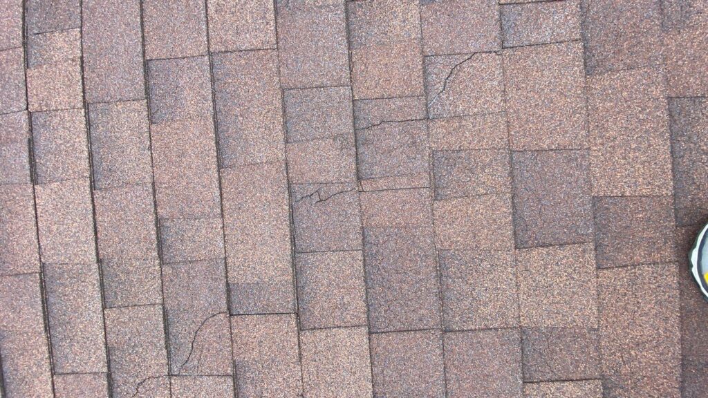 Cracks on asphalt shingles suggest that the shingles are overheating, allowing thermal expansion to fracture the shingles.