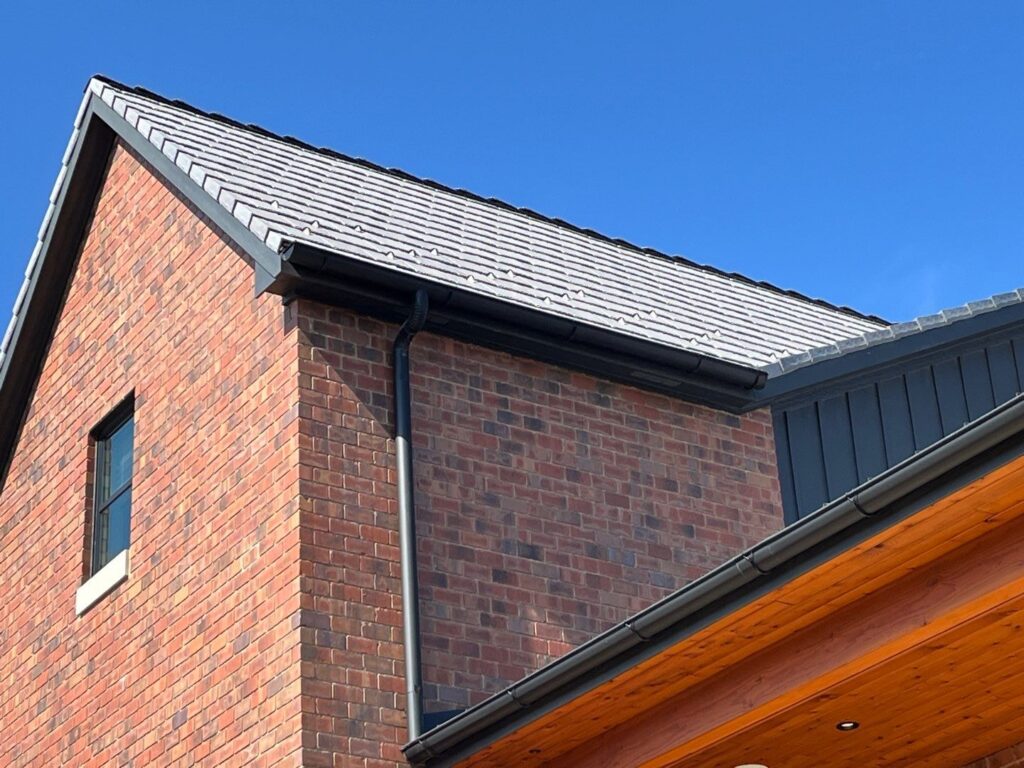 Low-profile snow guards on a tile roof as they appear from the ground.