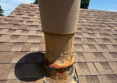 Severe rust on heater flue flashing with extensive previous repairs. This heater flue flashing was likely reused from the previous roof replacement.