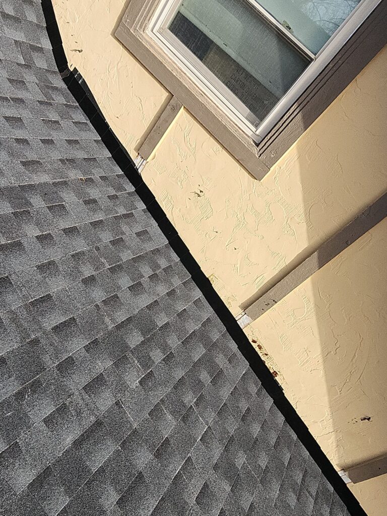 Black Step Flashing with Mild Siding Damage at Rake Wall Concrete Siding