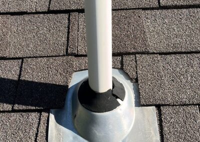 Pipe boot on a steep slope shingled roof with cracked rubber.