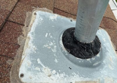 An incorrectly installed pipe boot with screws instead of nails, no shingle overlap, and severely cracked rubber.