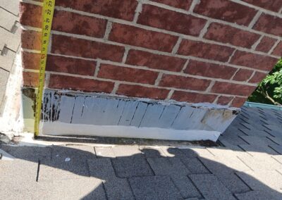 Previous repair attempts and rust are visible on this surface-mounted chimney flashing.