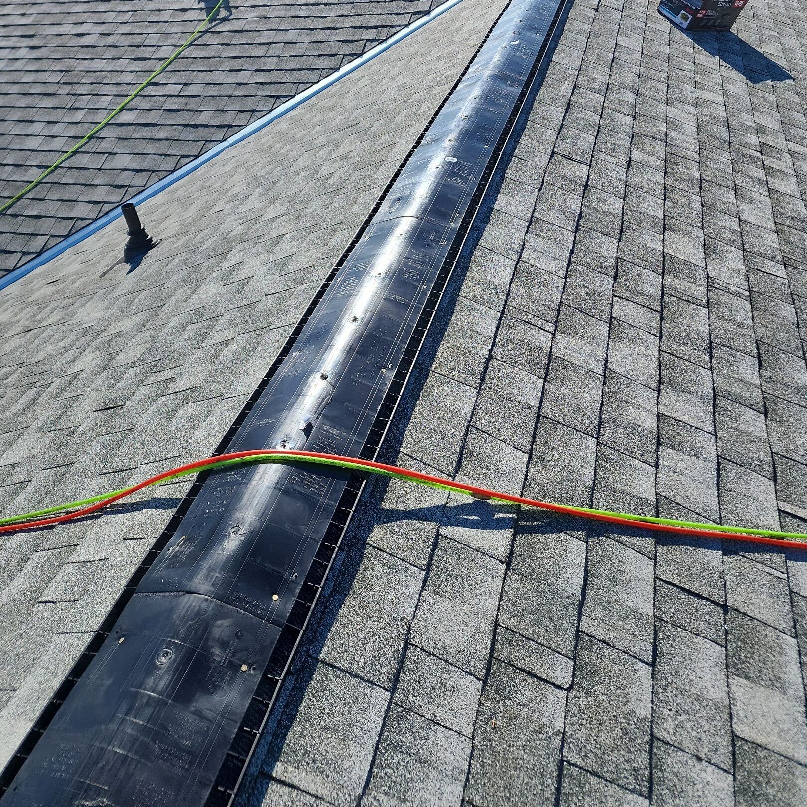 Ridge vent during installation on an asphalt shingle roof.