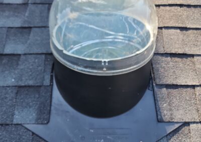 Sun tunnel installed on an asphalt shingle roof.