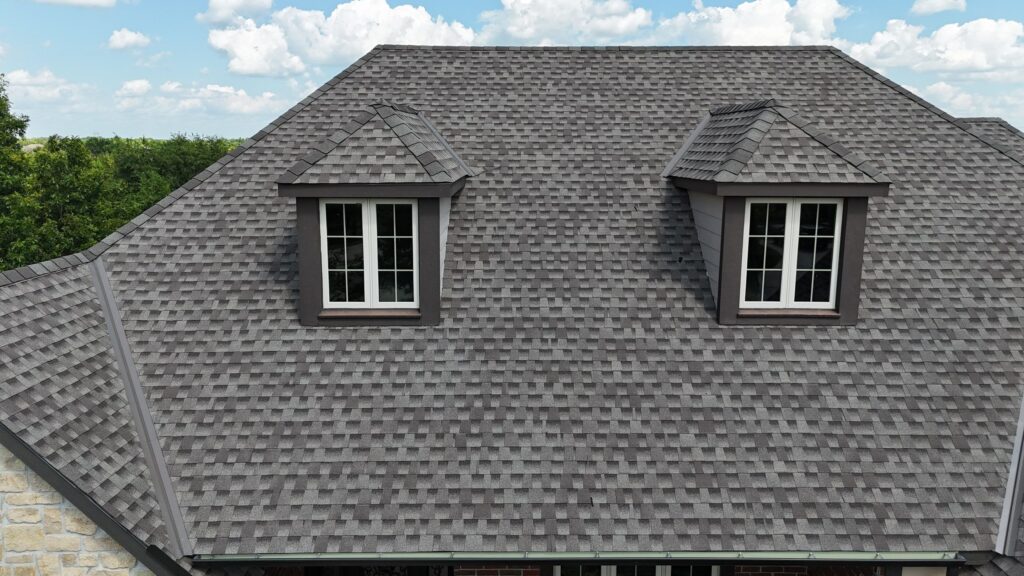 Two dormers on an asphalt shingle roof with a beauty bar over the headwall flashing downslope from the dormer.