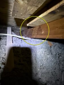 A rafter with water damage from inside of the attic space.