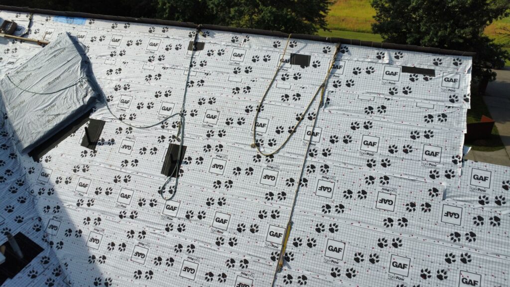 Premium synthetic underlayment covers the roof with pieces of ice and water shield and anchors for harnesses at the ridge.