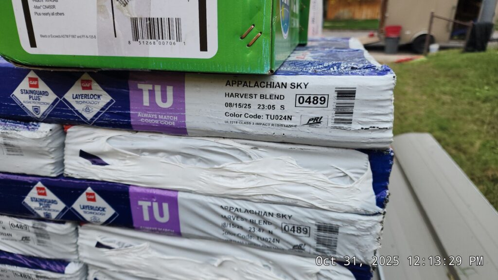 Packaged bundles of an uncommon asphalt shingle color before tear-off begins.