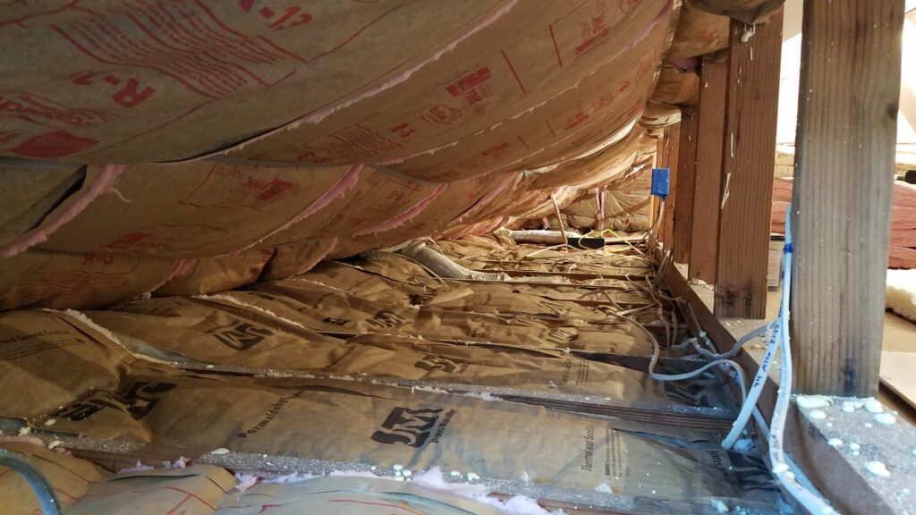 Knee-wall/eave attic space in a hot-roof retrofit, where extra insulation supplements closed-cell spray foam to reduce heat buildup and heat transfer.