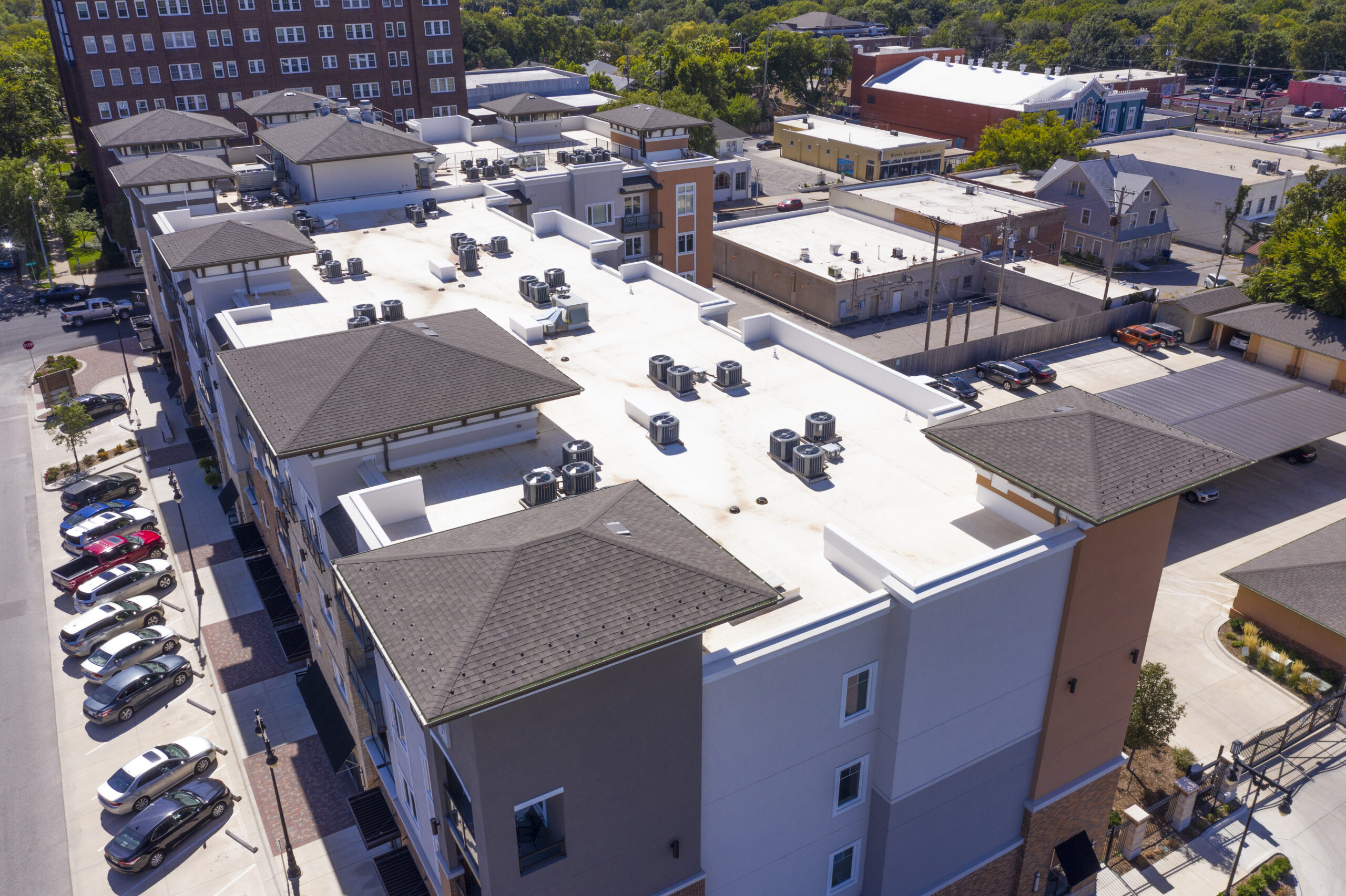A low-slope roof system paired with a steep-slope shingle accent on a four-story commercial building.