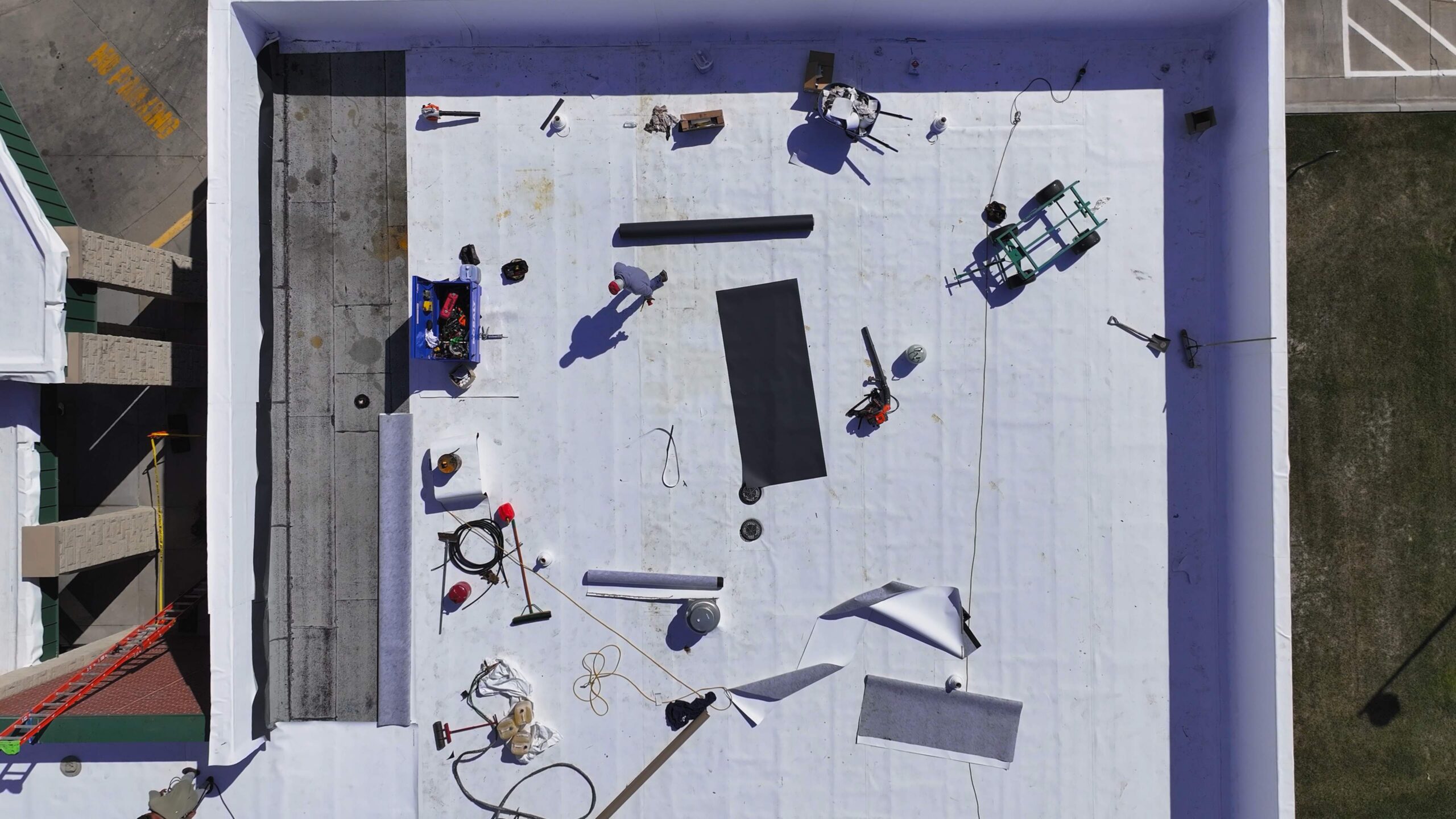 A fleeceback TPO membrane layover on a modified bitumen roof system during installation.
