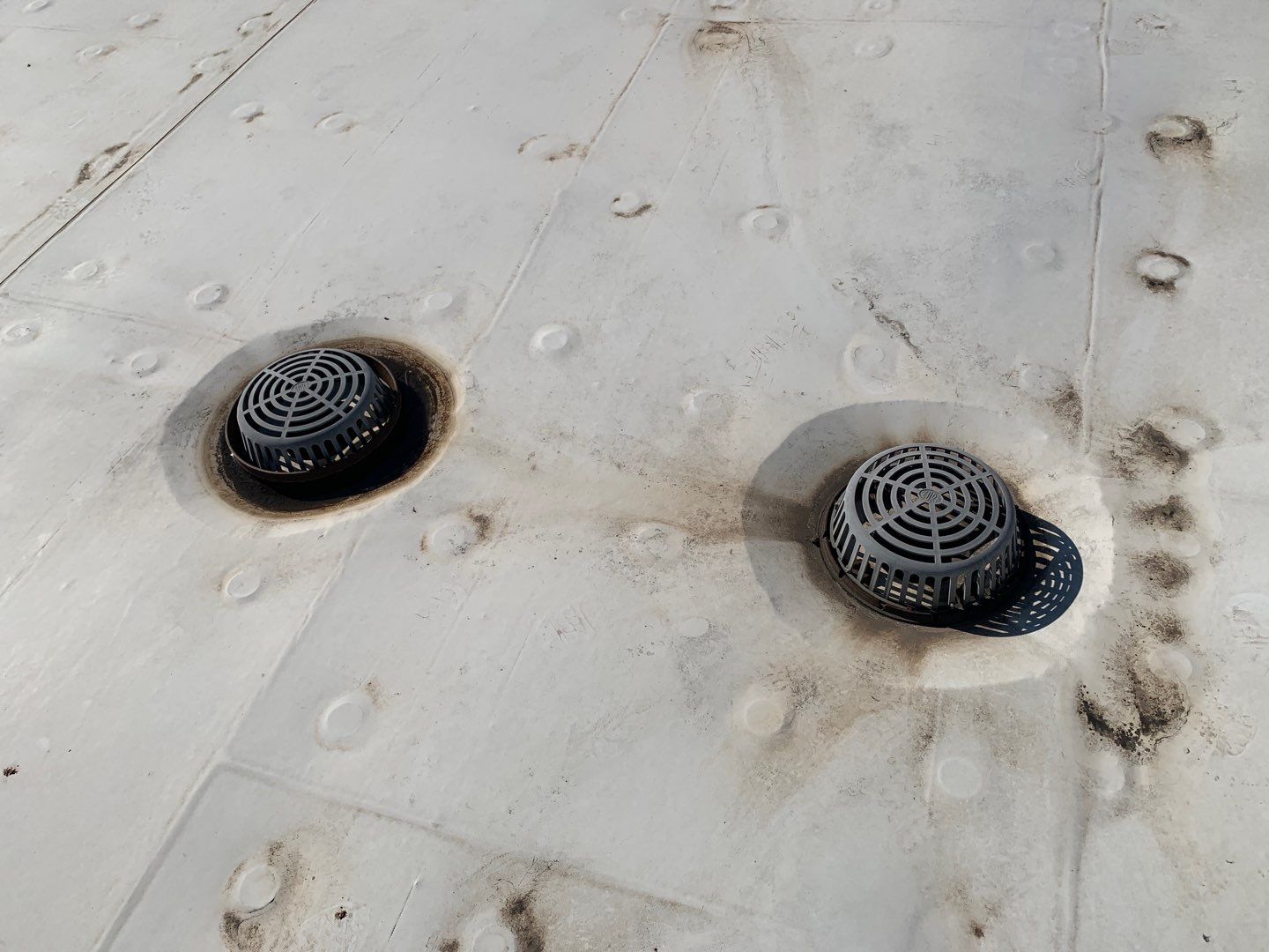 An internal drain placed above the primary internal drain on a low-slope commercial membrane roof.