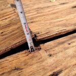 Buckled plywood roof decking showing an inch-and-a-half of elevation between buckled boards.