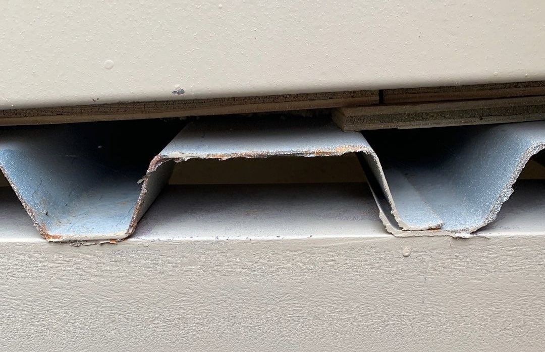 A metal roof deck visible from the roof hatch ladder well on a commercial building.