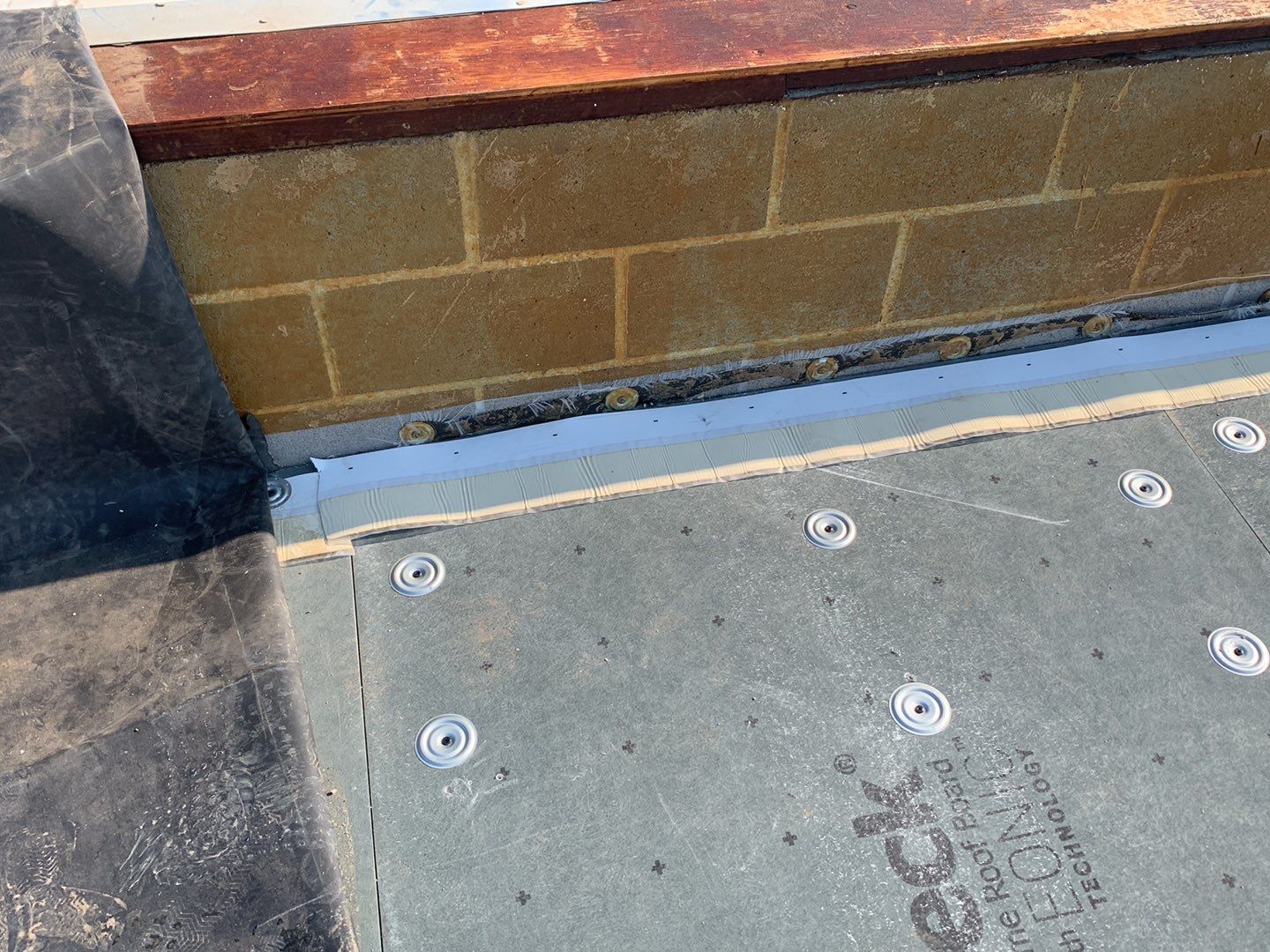 RUSS Strip at Parapet Wall A RUSS strip at the base of a parapet wall with a mechanically fastened cover board next to it.